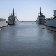 Photo of an inwater boom with four ships.
