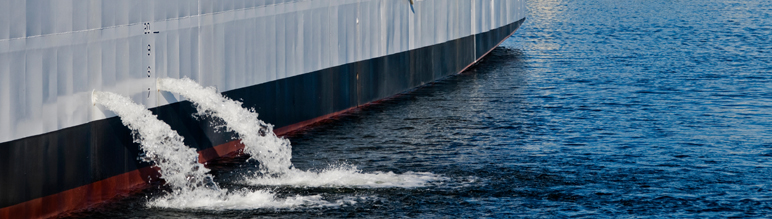 Ballast Water comes out the side of a large ship.